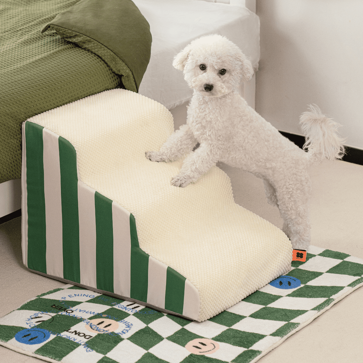 A dog climbing onto the couch using a green dog stairs